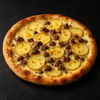 Pizza Pomme de Terre et Viande Hachée : Recette Gourmande Pizza gourmande avec fines tranches de pomme de terre dorées et morceaux de viande hachée brune sur une croûte cuite.