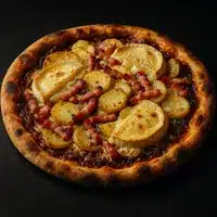 Pizza Reblochon Pommes de Terre Lardons Artisanale Pizza gourmande aux pommes de terre, lardons et morceaux de reblochon fondus, sur une croûte bien dorée.
